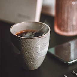 Photographie de nature morte, tasse de café de spécialité, ambiance chaleureuse.